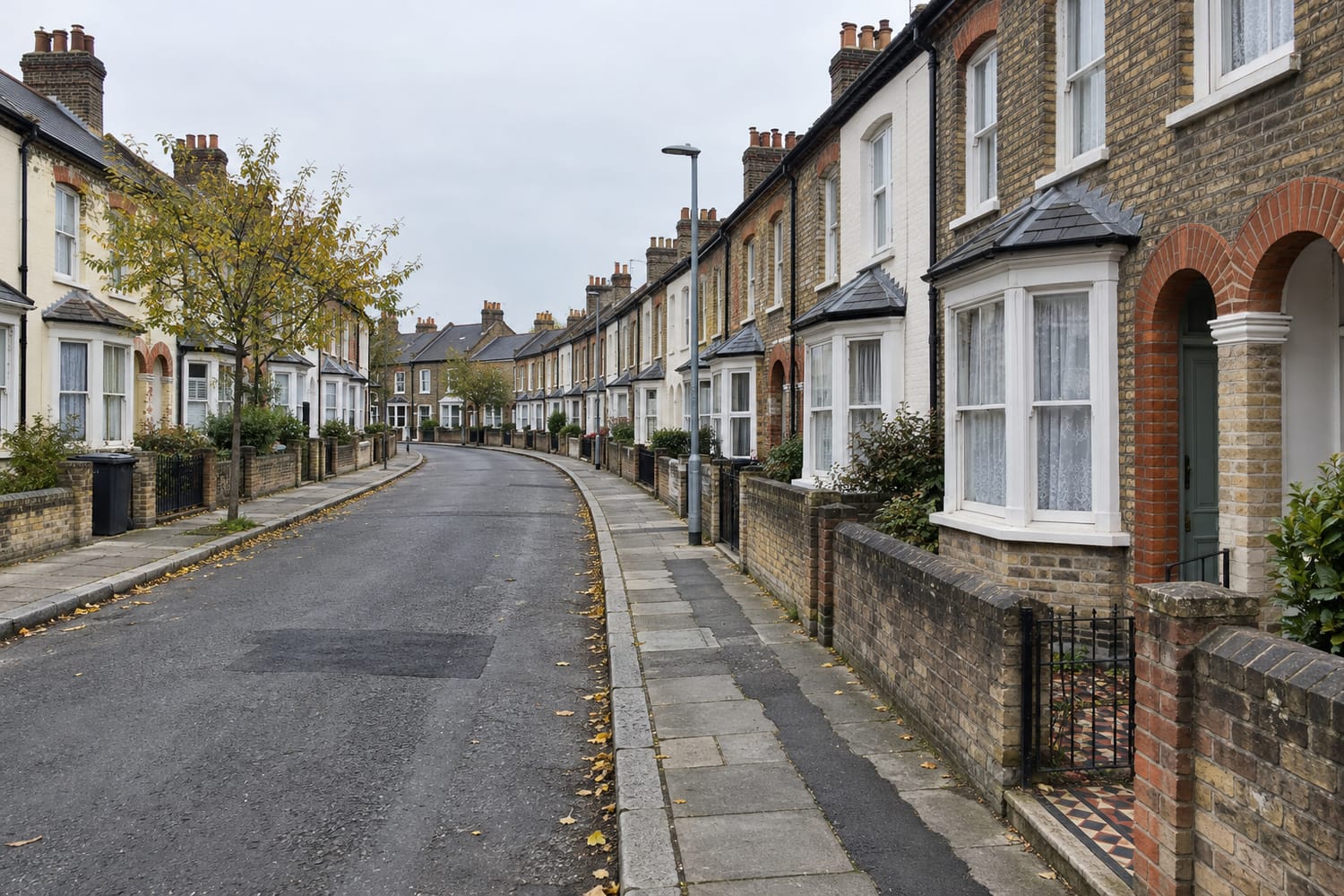 A gently curving street of two-storey yellow brick terraced houses with bay windows and low front walls, seen along the pavement