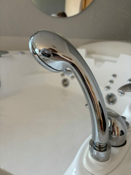 Chrome shower handset on a whirlpool bath