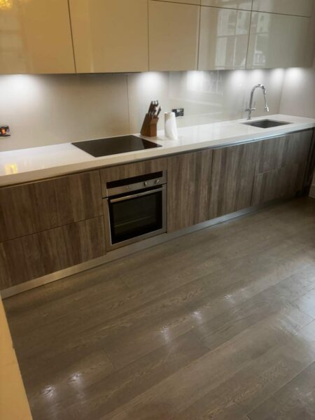 Fitted kitchen with wood-effect units and a polished floor