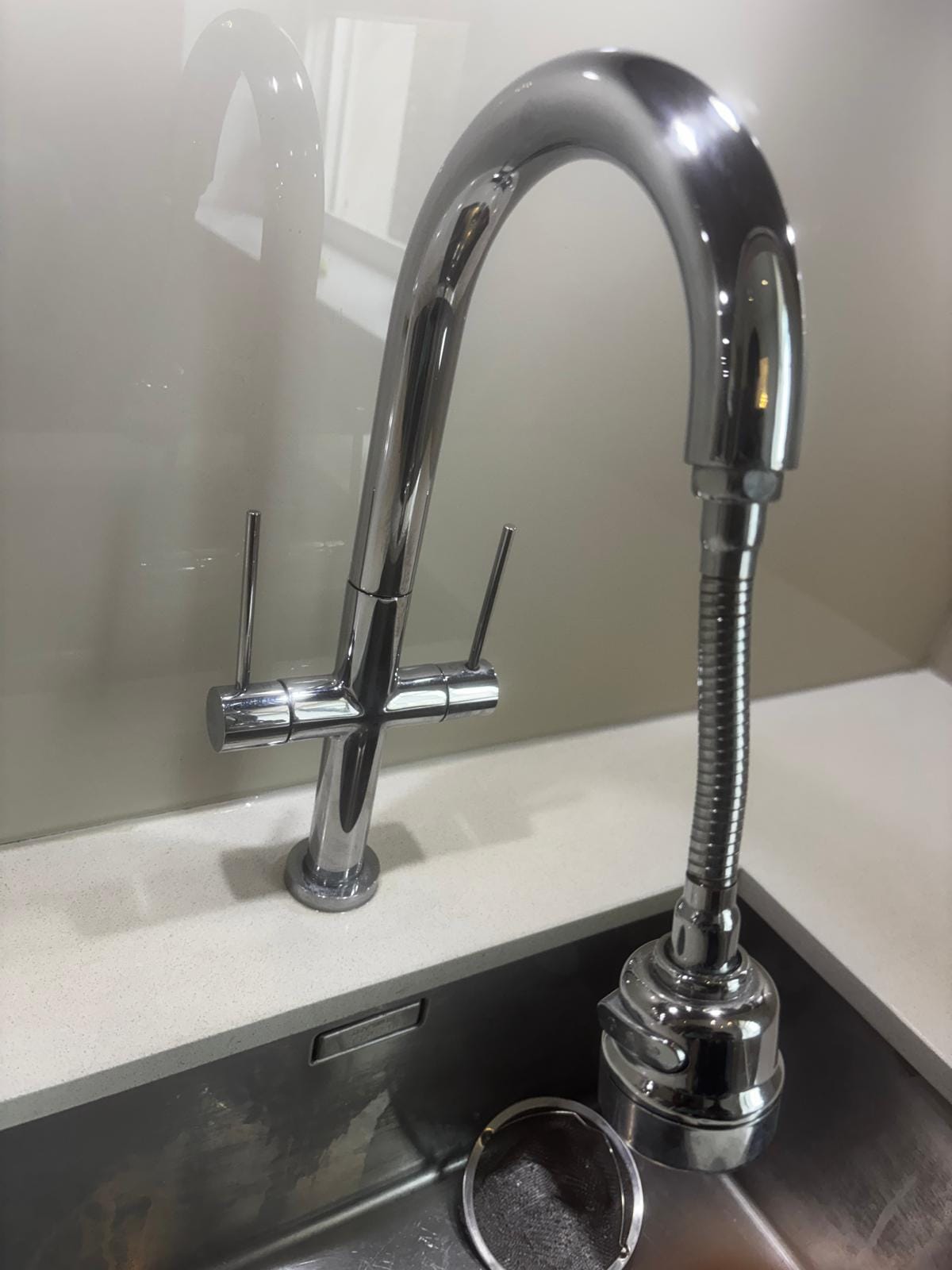 Chrome kitchen tap over a stainless steel sink