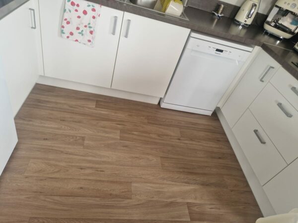 Kitchen with white units and a wood-effect floor