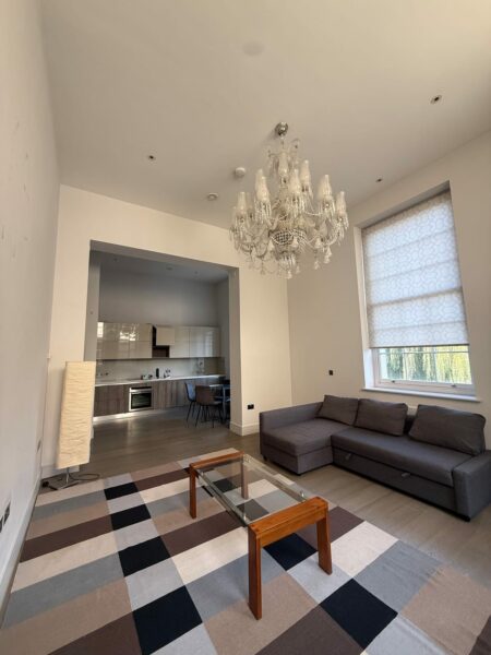 Open-plan living room with a chandelier and a checked rug
